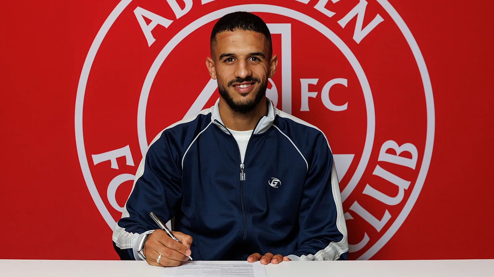 Ayoub Mouloua Aberdeen FC ile sözleşme imzalarken gülümsüyor