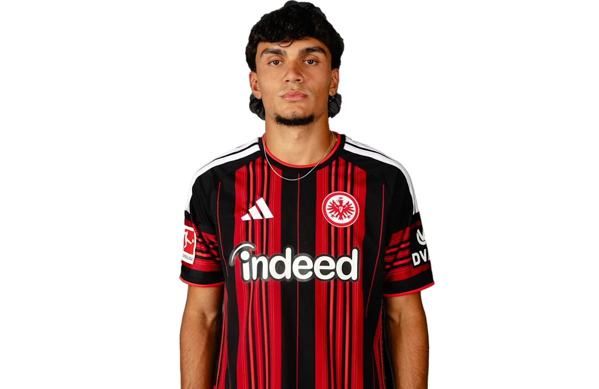Can Uzun, Eintracht Frankfurt forması giyerken kameraya poz veriyor