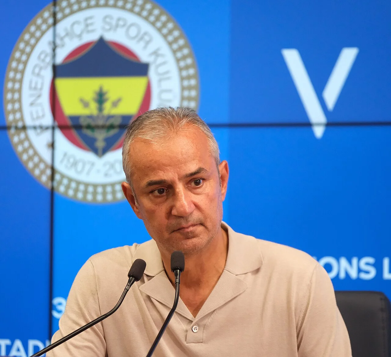 Fenerbahçe teknik direktörü İsmail Kartal, kulüp amblemi önünde basın toplantısında